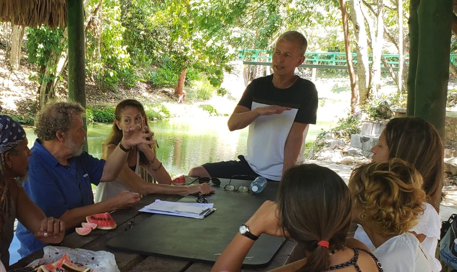 Roberto Suárez teaching a small group of students at an outdoor table