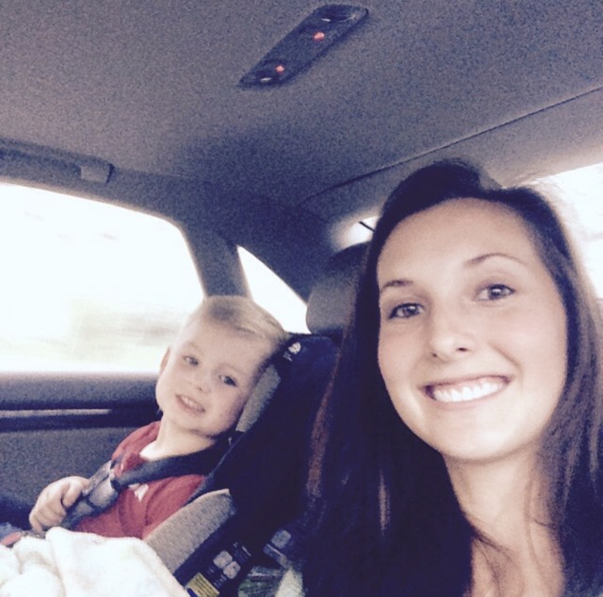 Kierstin and her young son smiling in the car