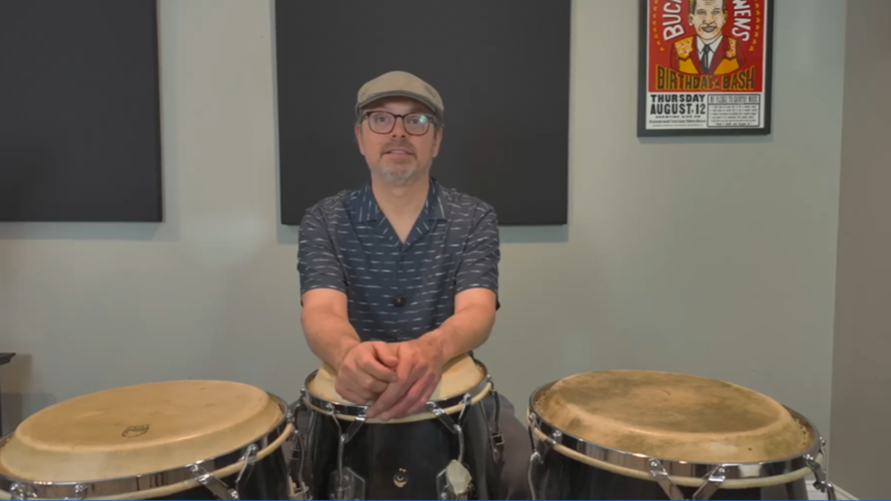 Ryan Lacey sitting behind conga drums