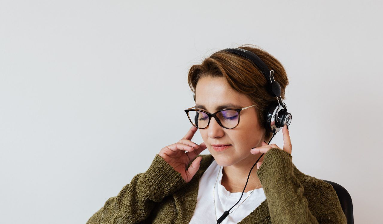 Woman with headphones and eyes closed representing the guided audio and reflection prompts inside Found(N)ation Unlocking YOU