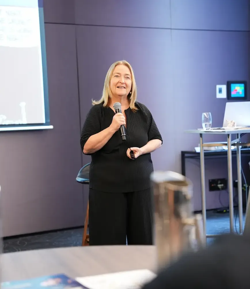 A woman business coach giving a presentation at an event