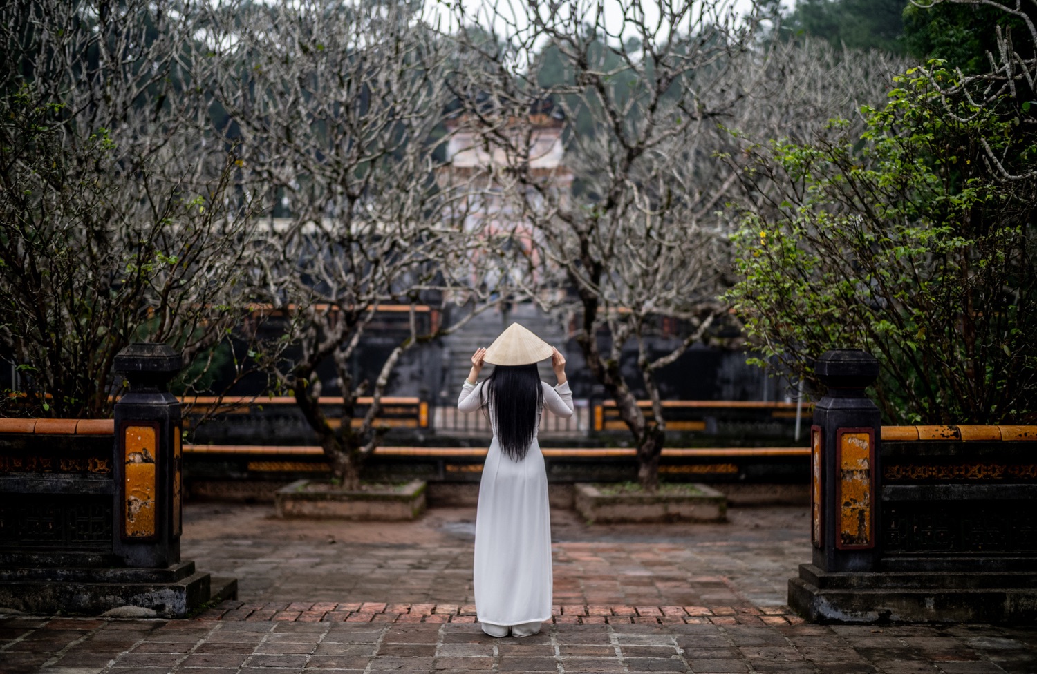Woman in ao dai at the royal tombs in Hue, Vietnam