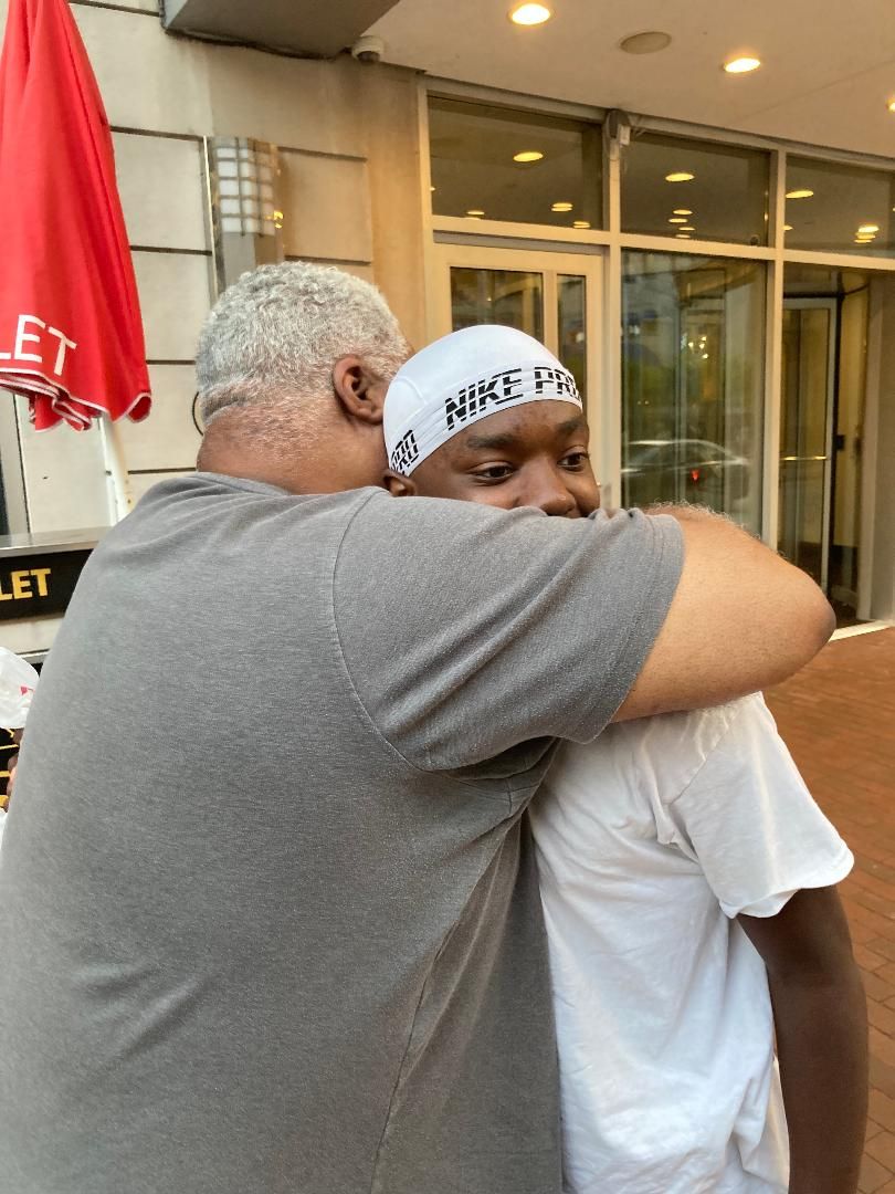 A parent embracing their child before leaving for military service
