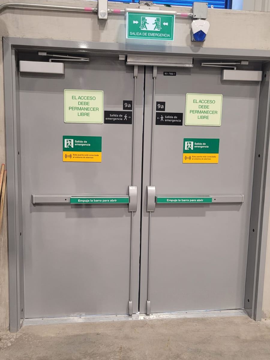 Puerta doble metálica de salida de emergencia con barras antipánico instalada en IKEA