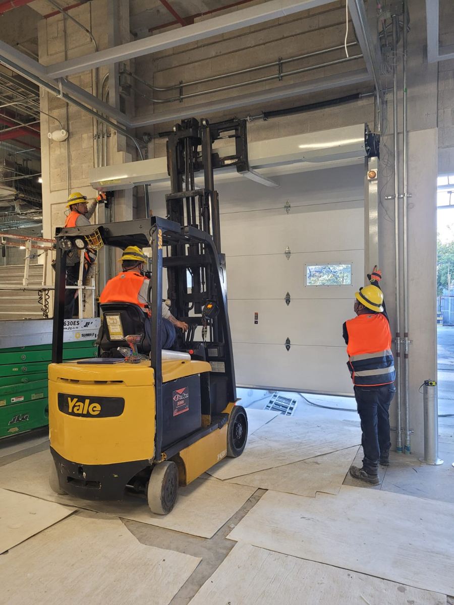 Equipo de MIFE instalando puerta de andén con montacargas en obra