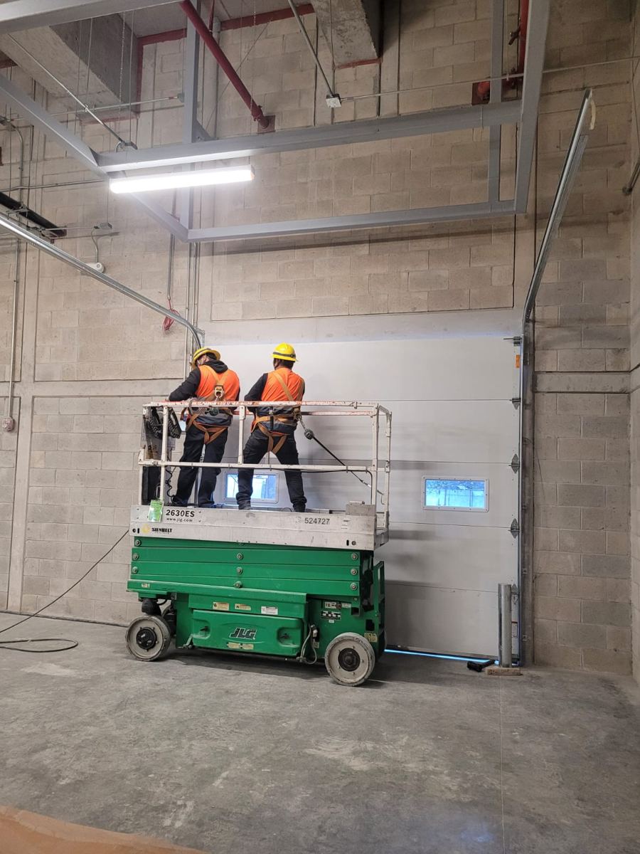 Instaladores de MIFE trabajando en altura sobre plataforma de tijera