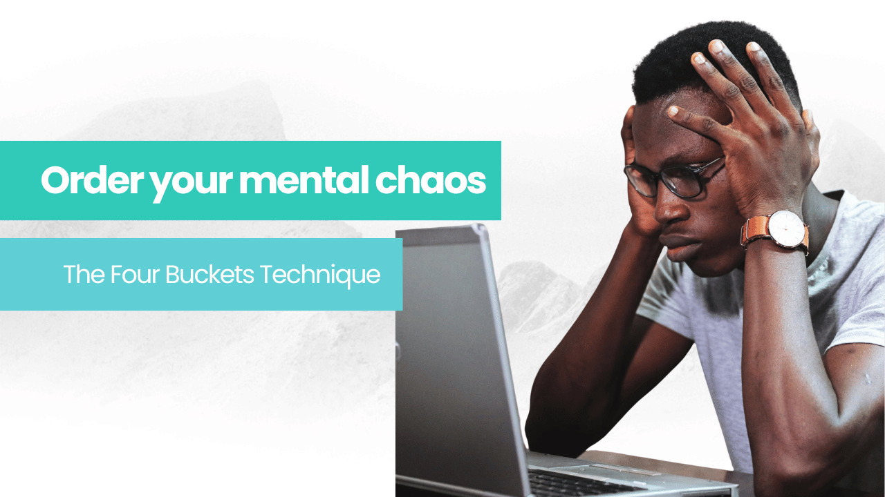 A man experiencing mental chaos is sitting at a desk with his hands on his head looking at a laptop