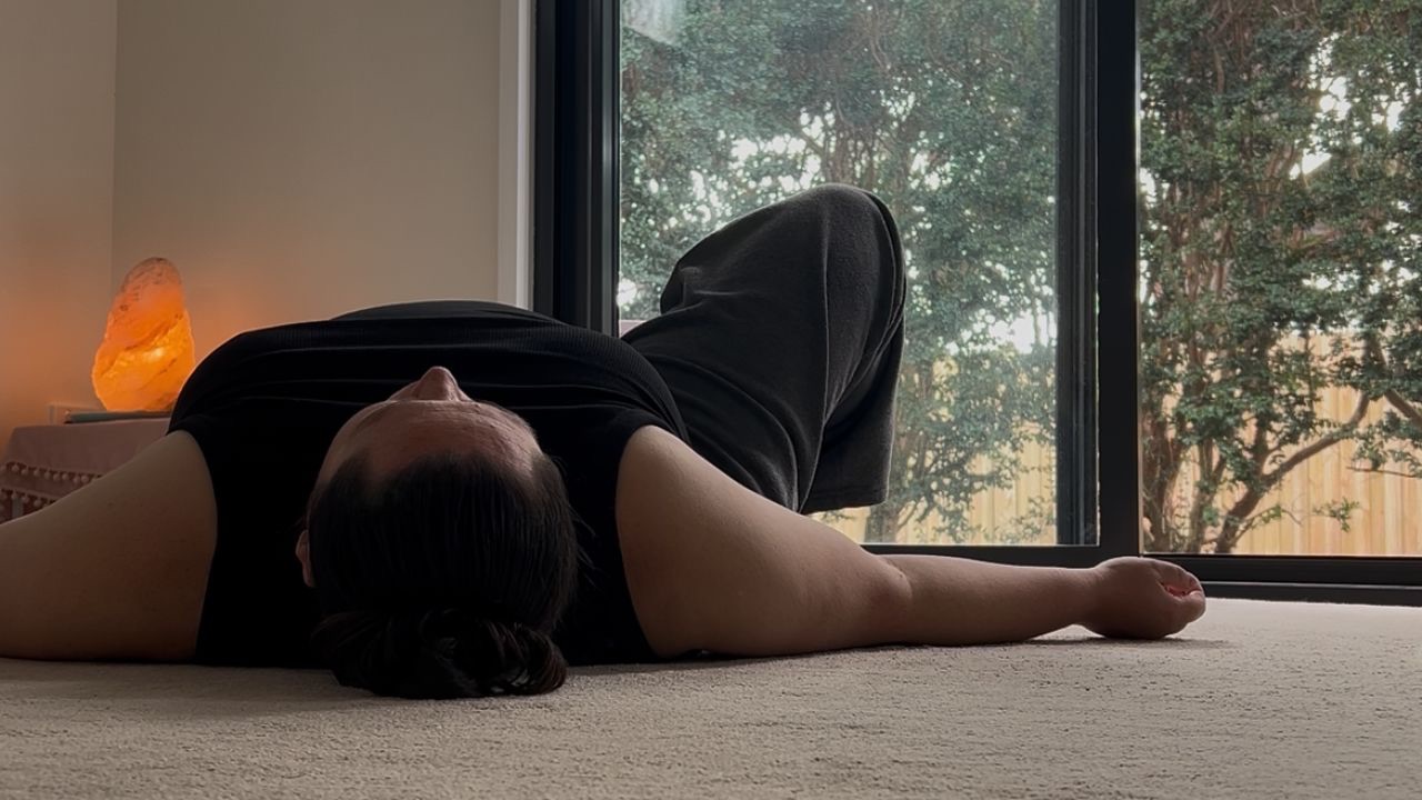 Restorative movement practice lying on the floor in gentle windshield wipers for nervous system regulation and release of stress