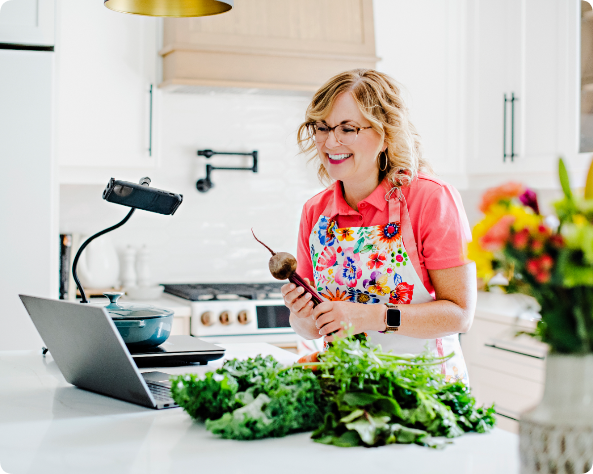 Lynne preparing food during a private cooking workshop, filmed with a laptop and ring light