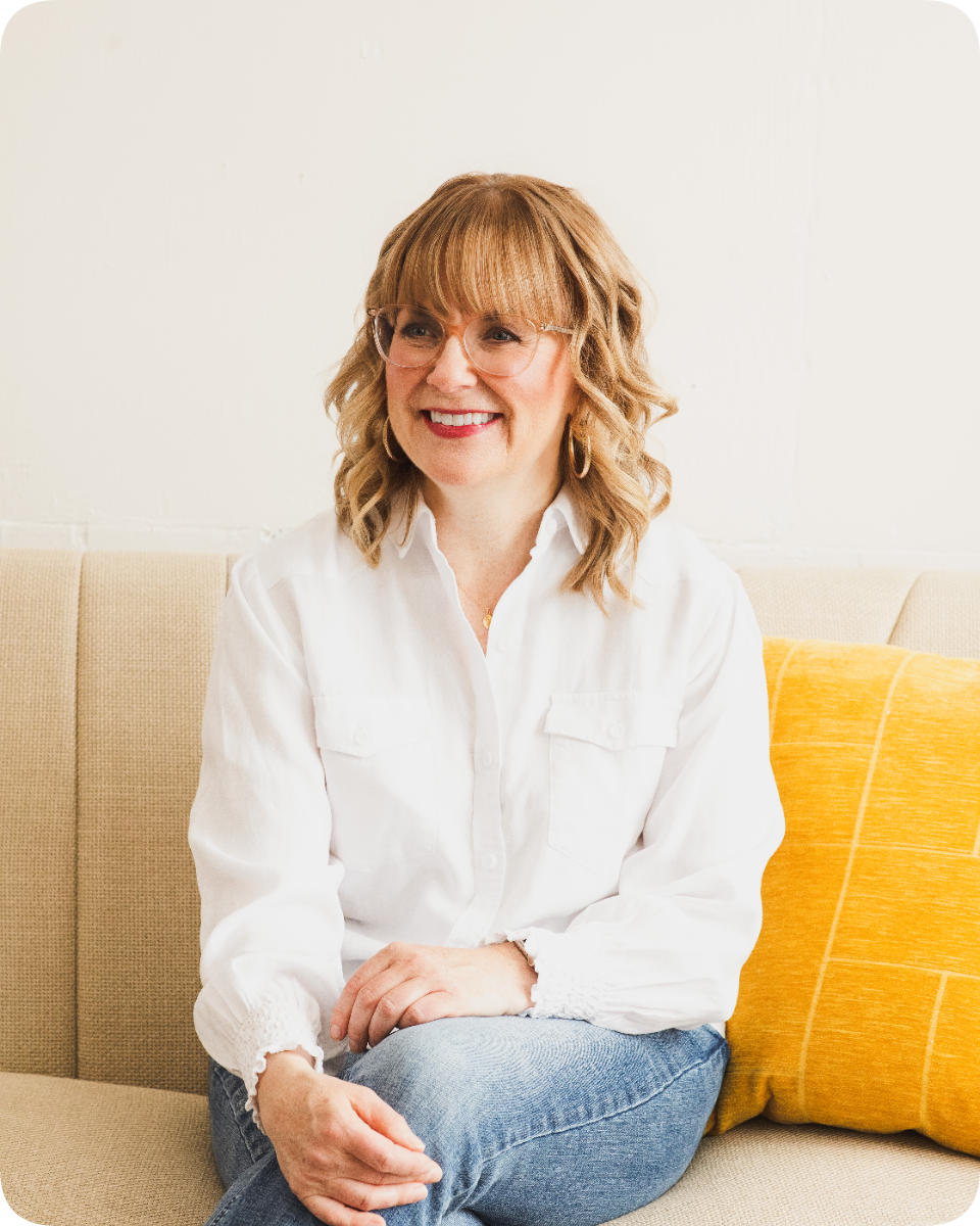 Lynne Zimmerman, chef and culinary nutritionist, smiling while sitting on a couch