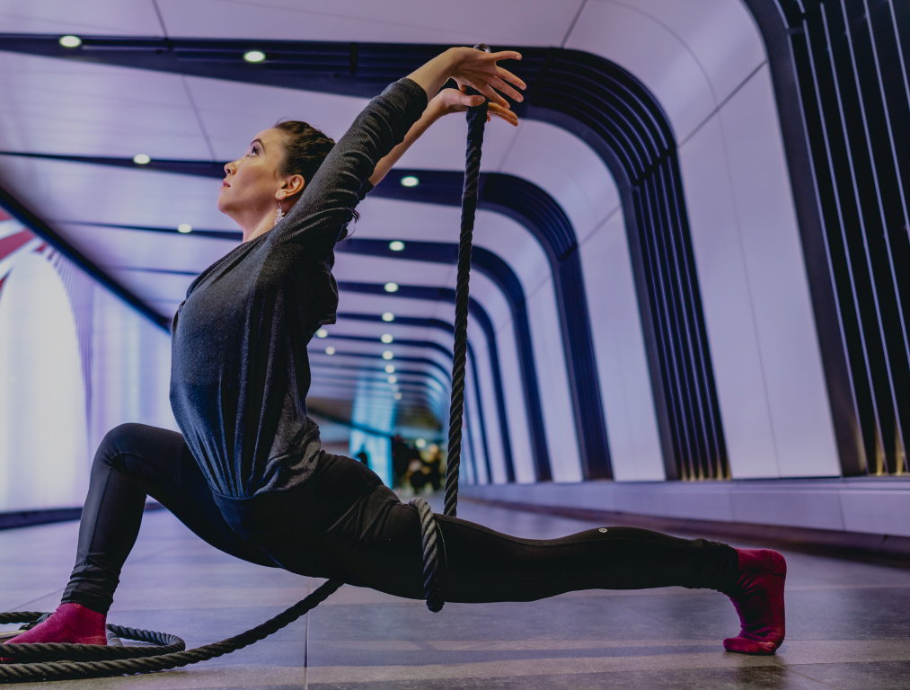 Enya White in a deep lunge stretch using a resistance rope