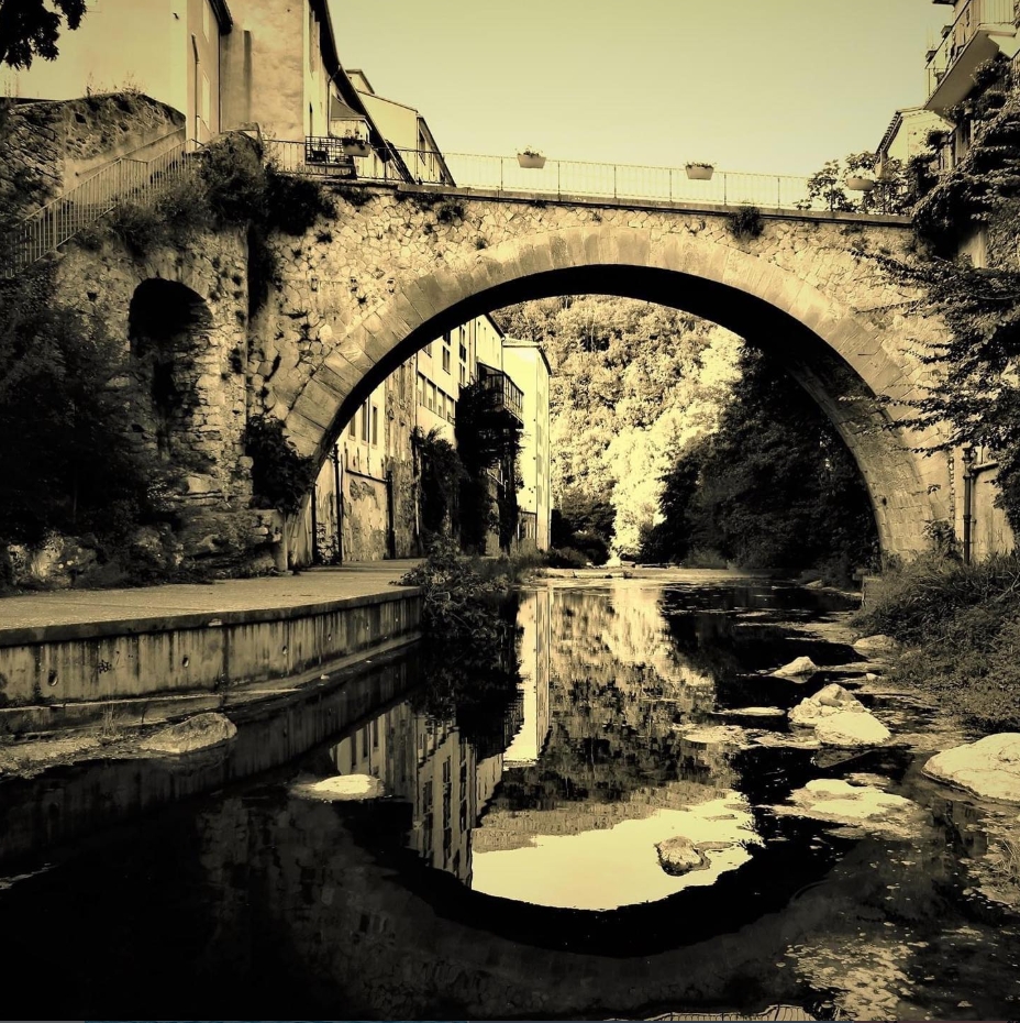 A stone arch bridge and its reflection