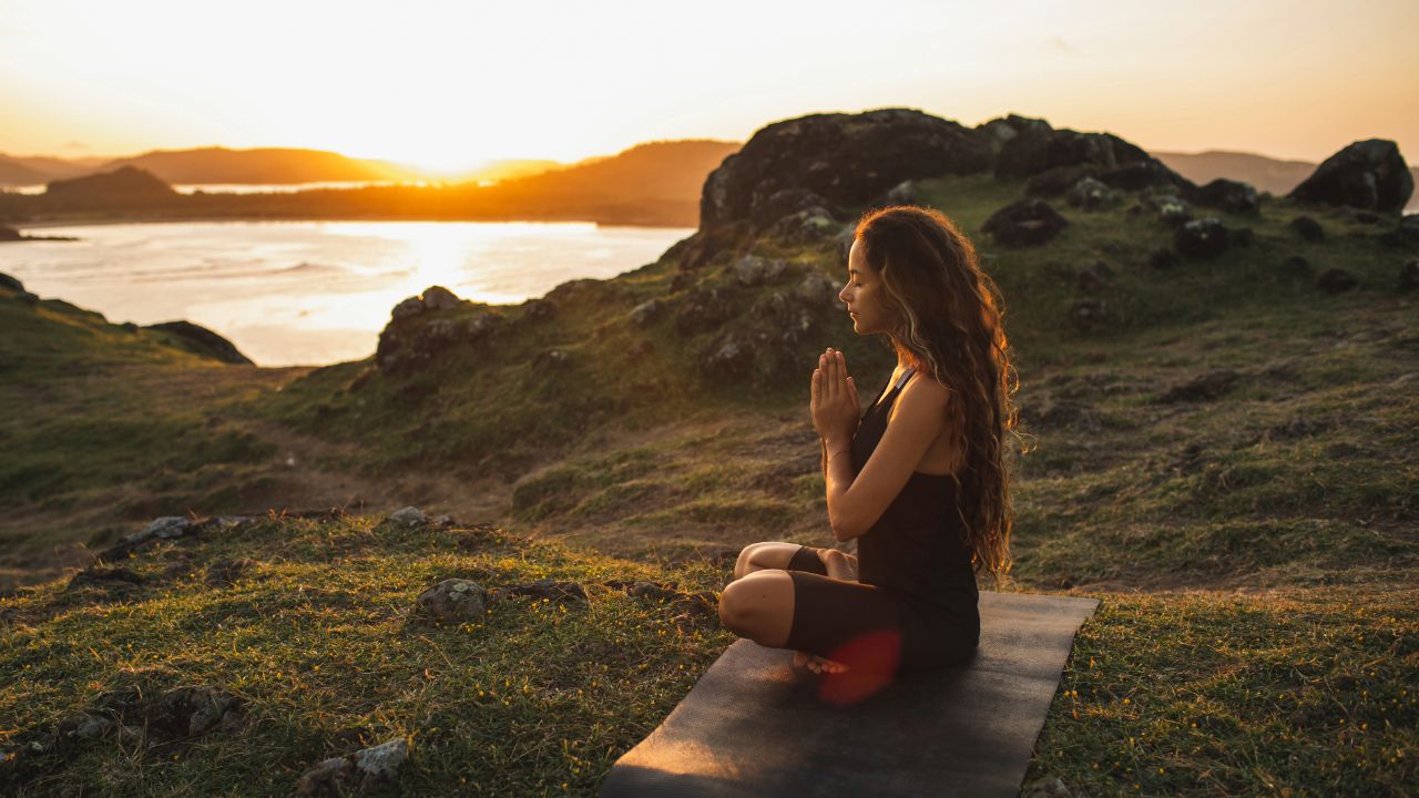 woman meditating on the beach
