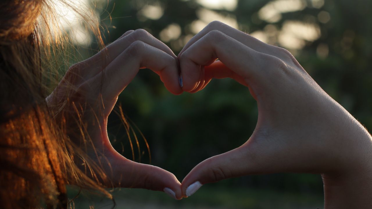 person making heart with hands after improving self-acceptance