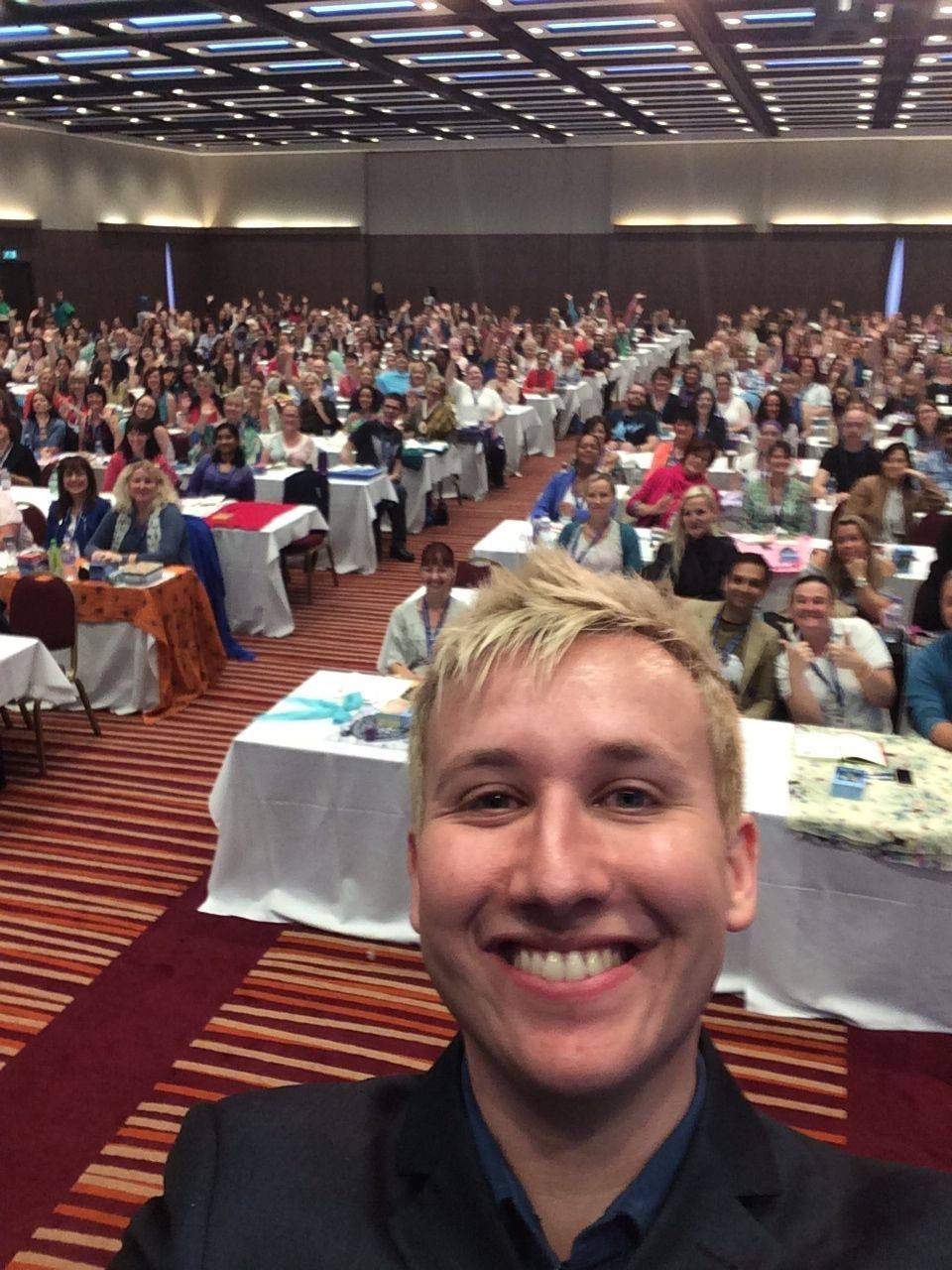 Robert Reeves taking a selfie with a large seminar audience