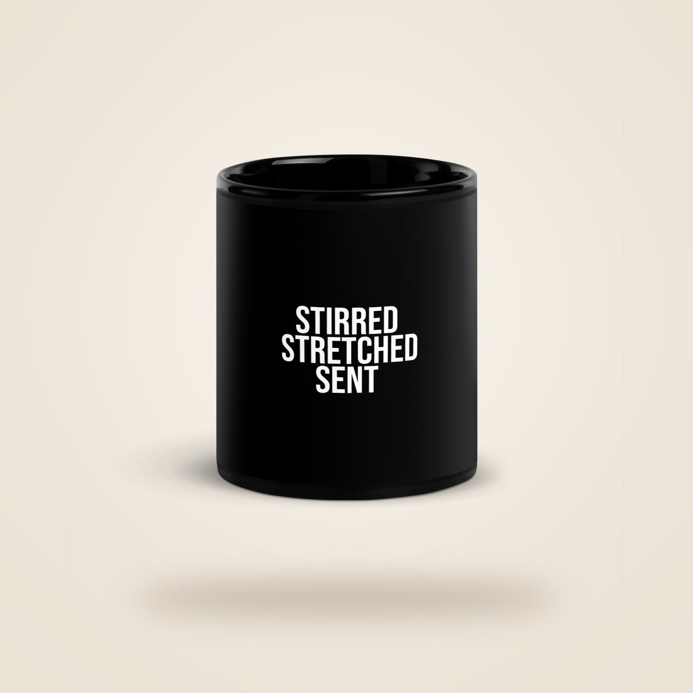 Black mug reading STIRRED STRETCHED SENT