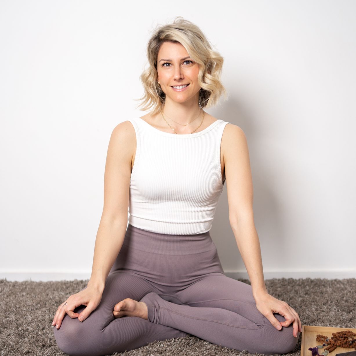 Photo of Rebecca Michelle, a personal meditation coach sitting crossed legged prepared for meditation.