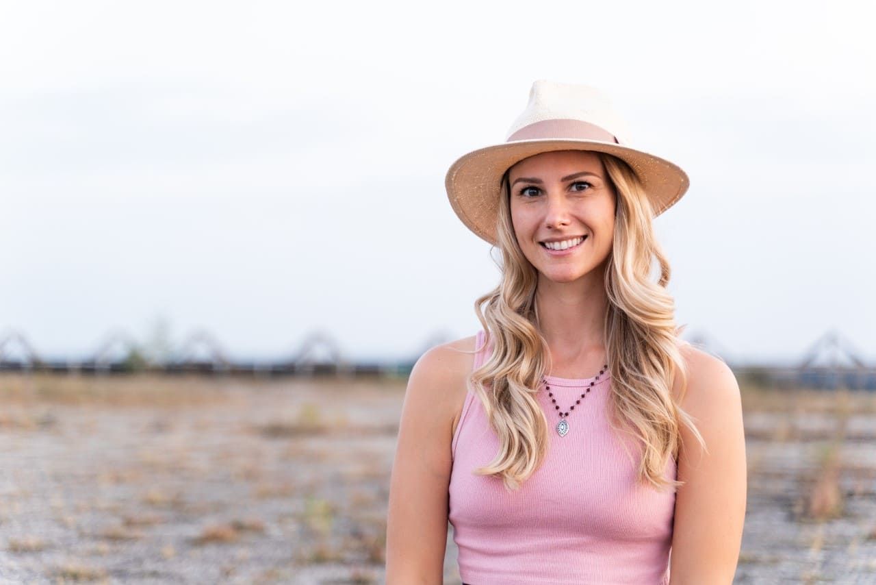 A photo of Rebecca Michelle a personal mindfulness coach from nyc. She is smiling and has a beige hat on.