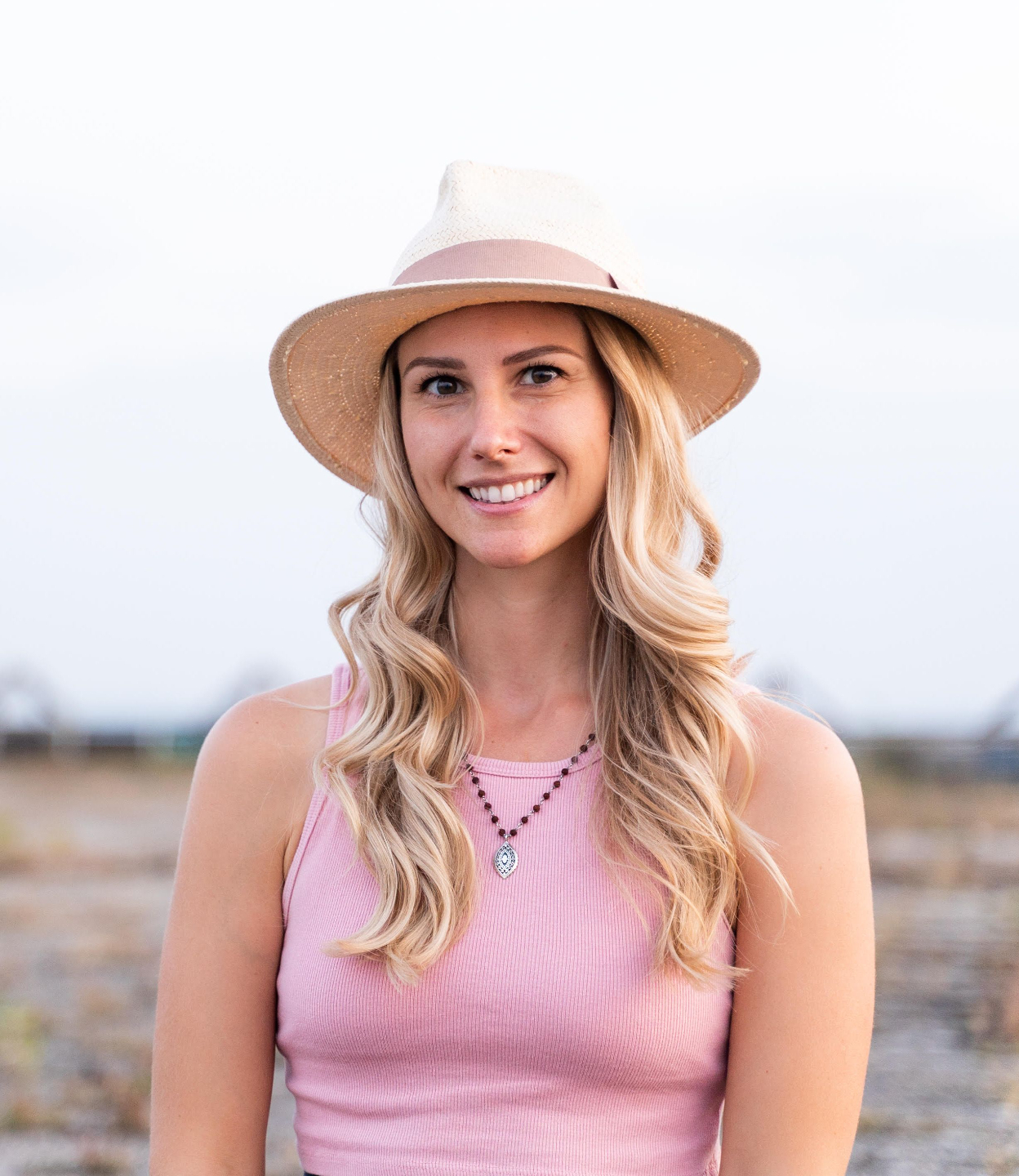 A photo of Rebecca Michelle, a meditation coach who has a hat on and is smiling.