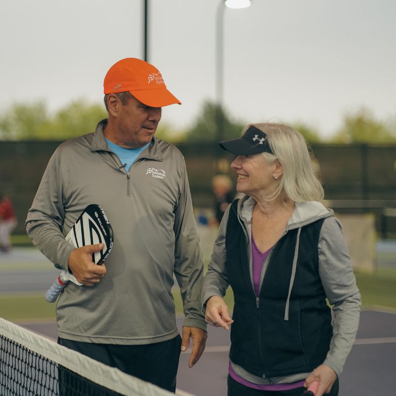 Tony Roig, pickleball coach, working with a player on court at a pickleball camp