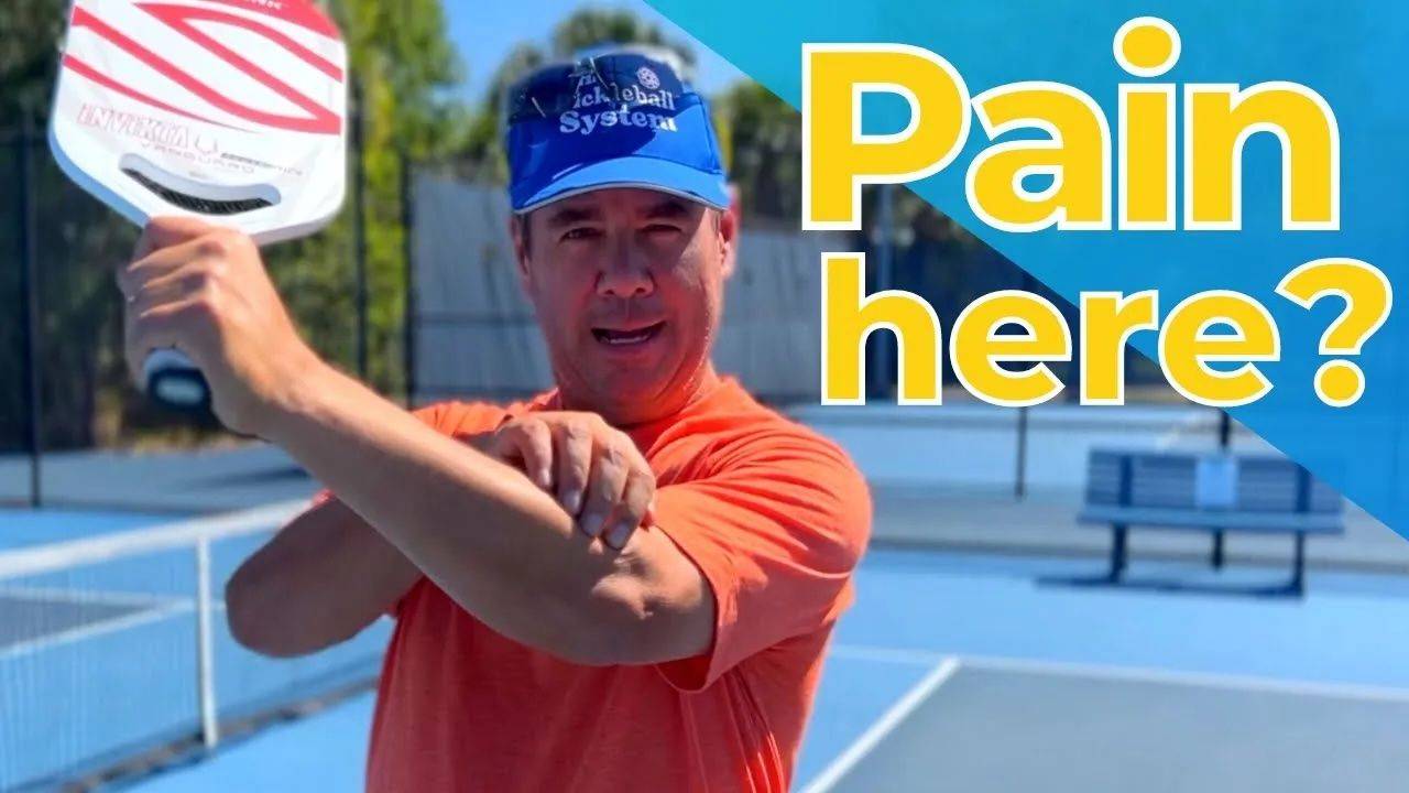 Tony Roig holding his forearm on a pickleball court, illustrating elbow and forearm pain from playing pickleball