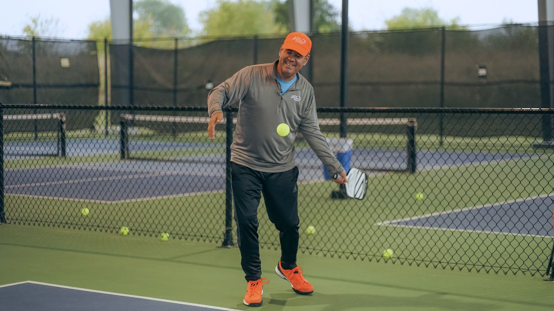 Pickleball player serving underhand with an upward paddle swing