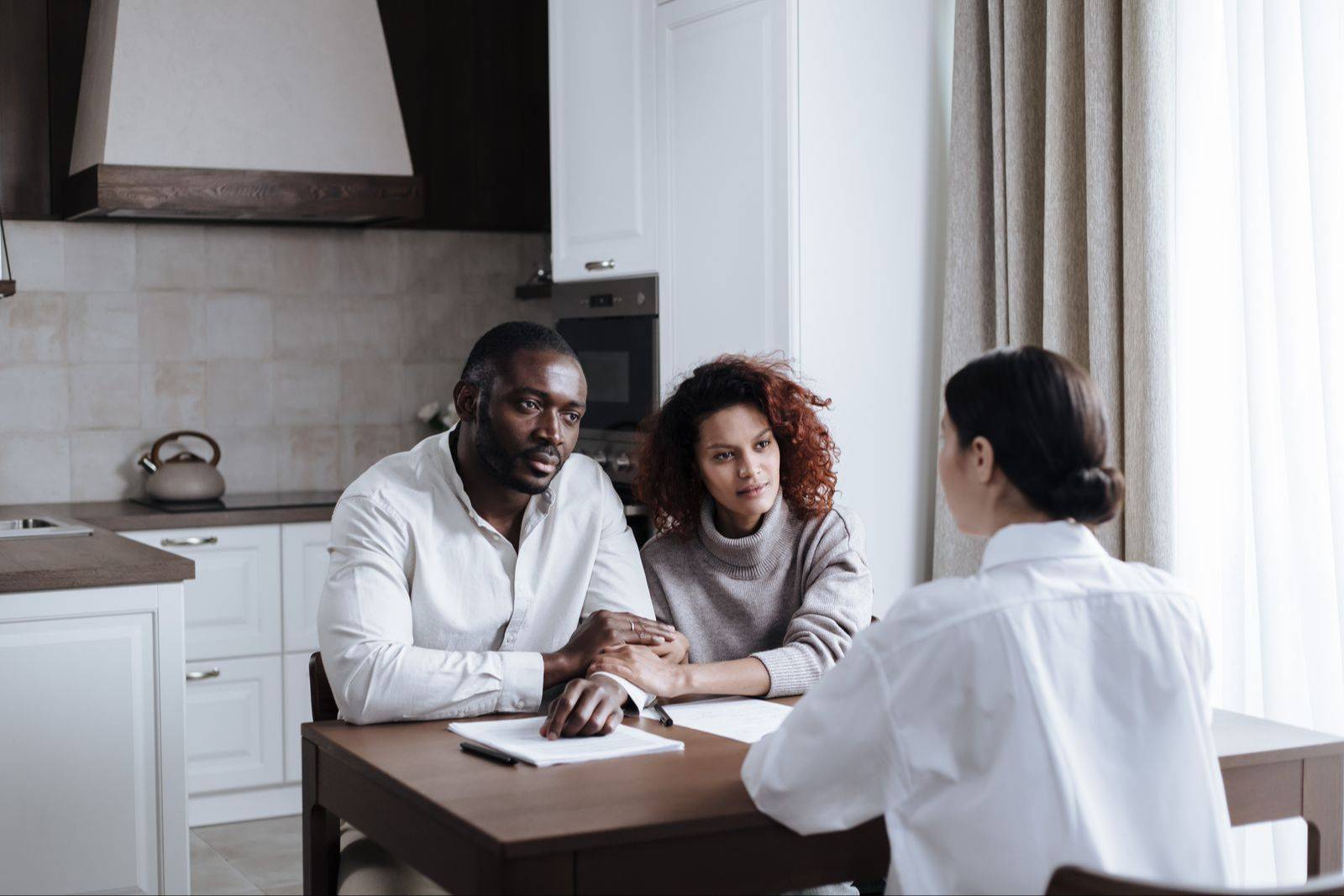 Child welfare professional meeting with a family at their kitchen table