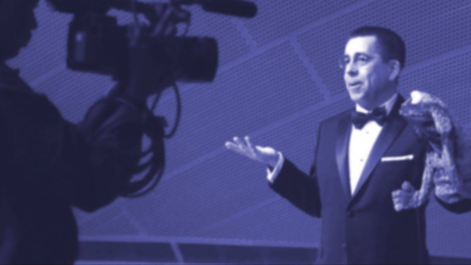 Mike Quinn performing with a puppet during a filmed stage presentation