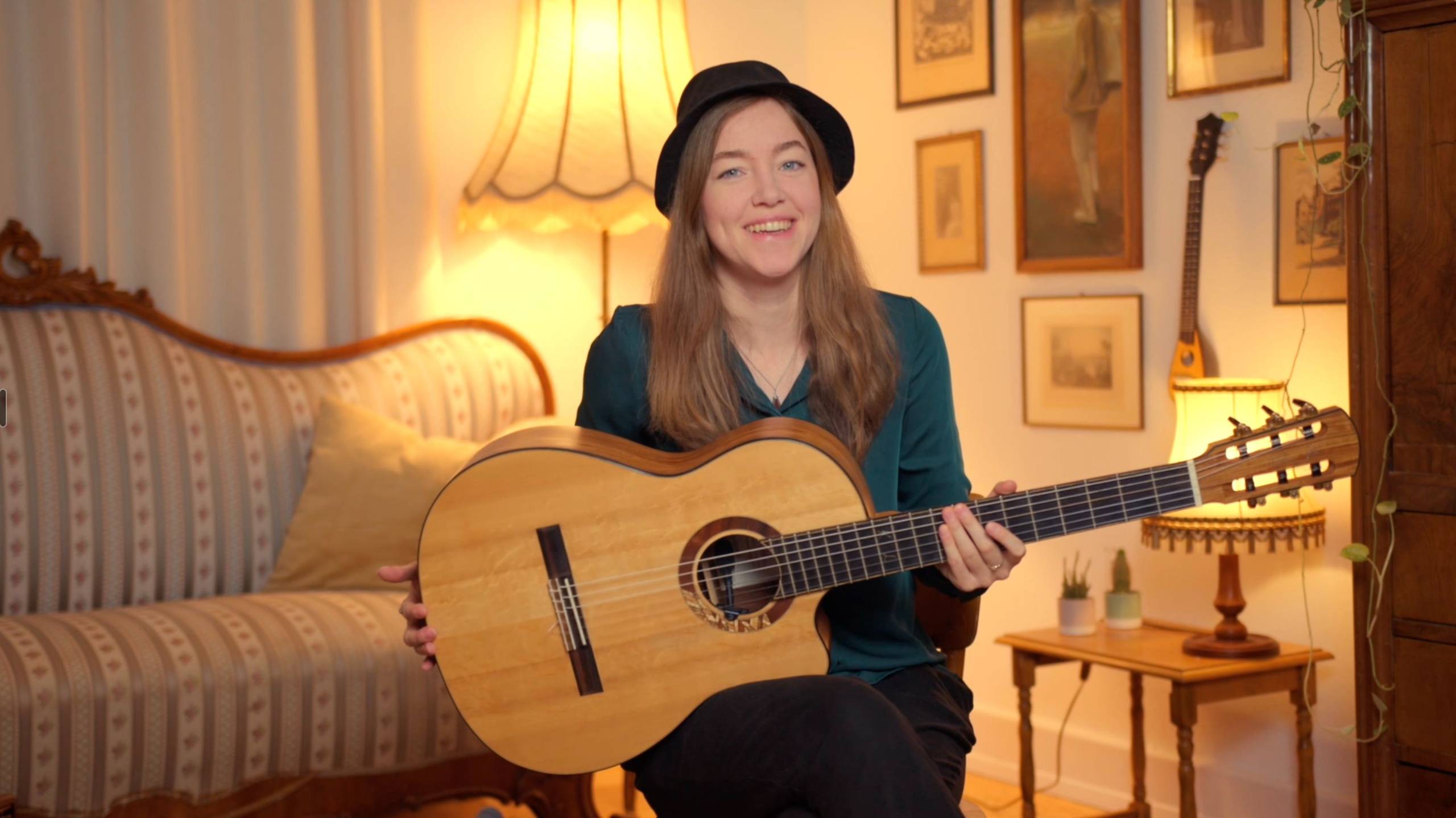 Karlijn Langendijk with her guitar in a warmly lit living room