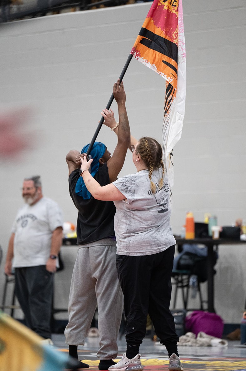 A colorguard group raising their hands together