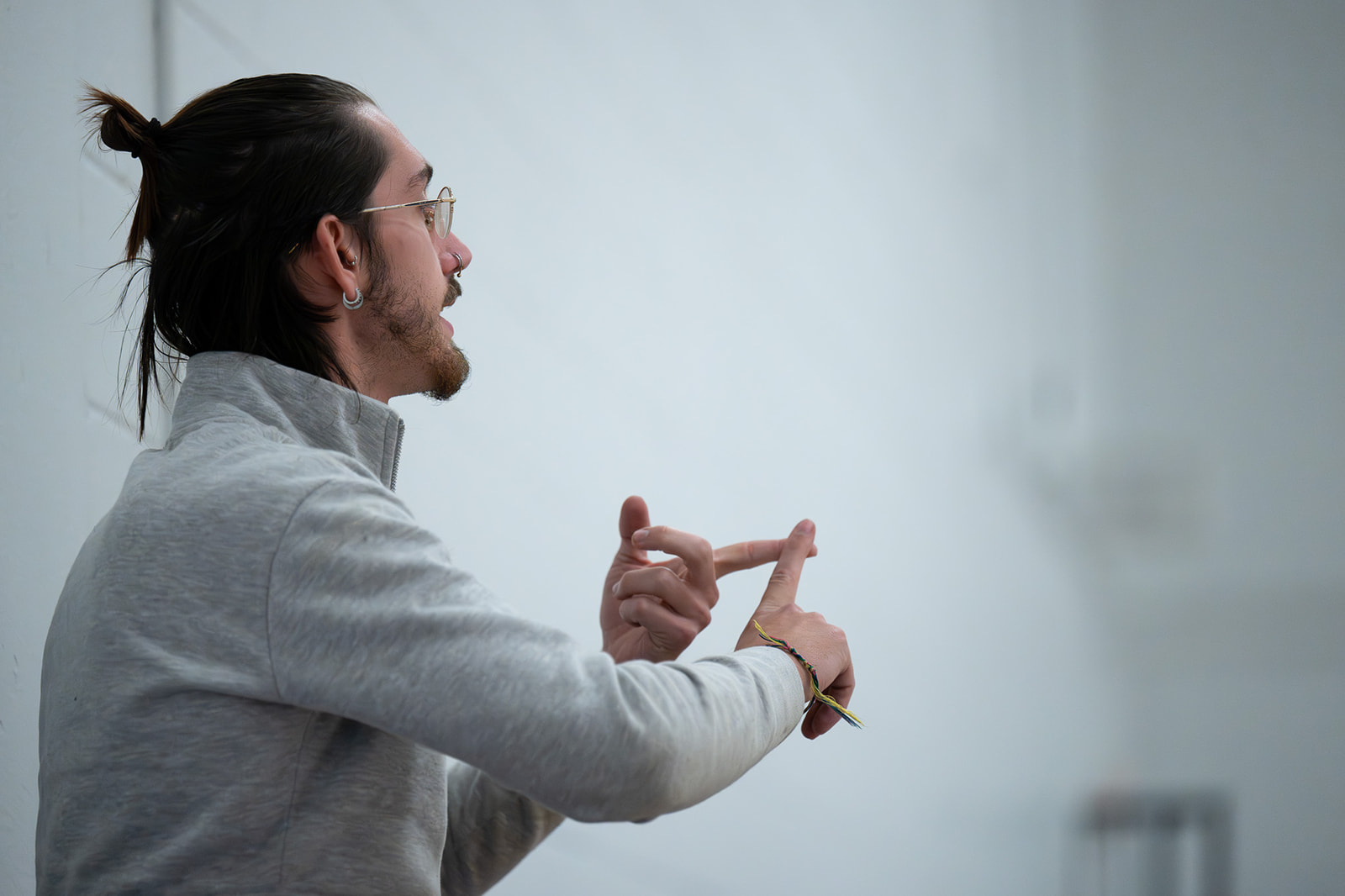 A colorguard instructor explaining a concept with his hands during rehearsal