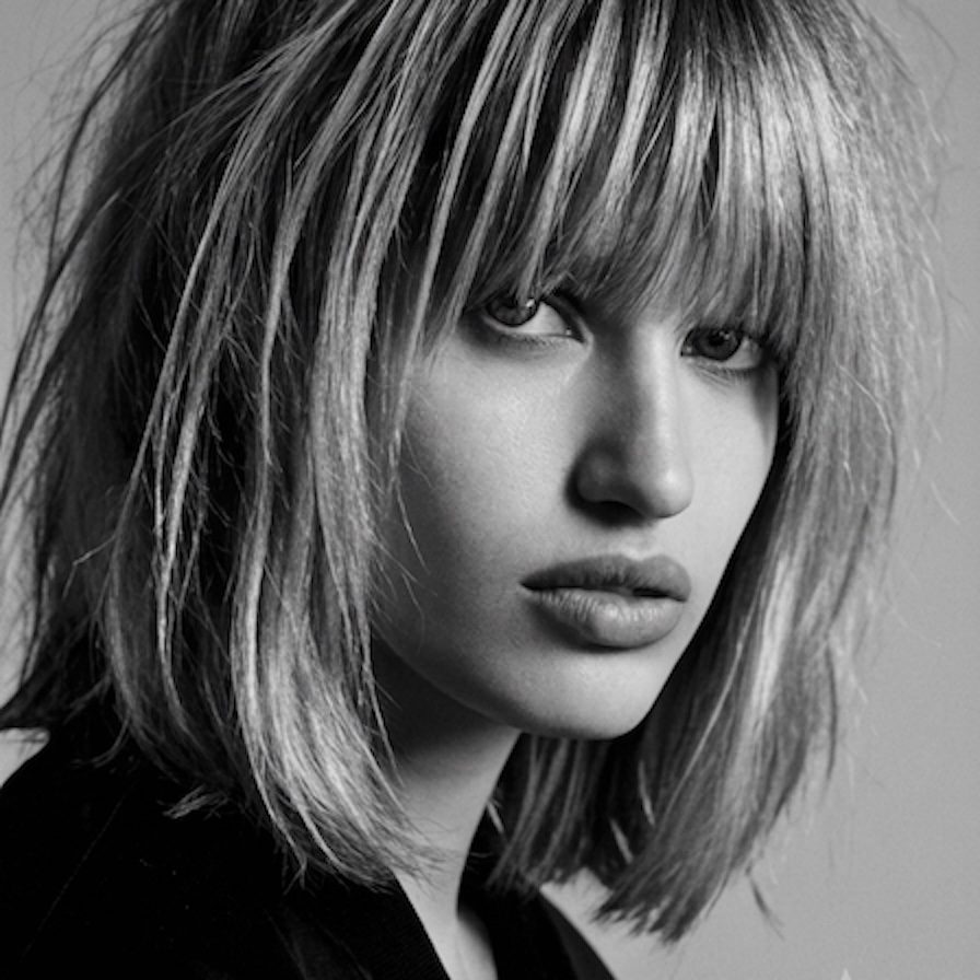 Woman with a blonde-highlighted shag haircut and bangs