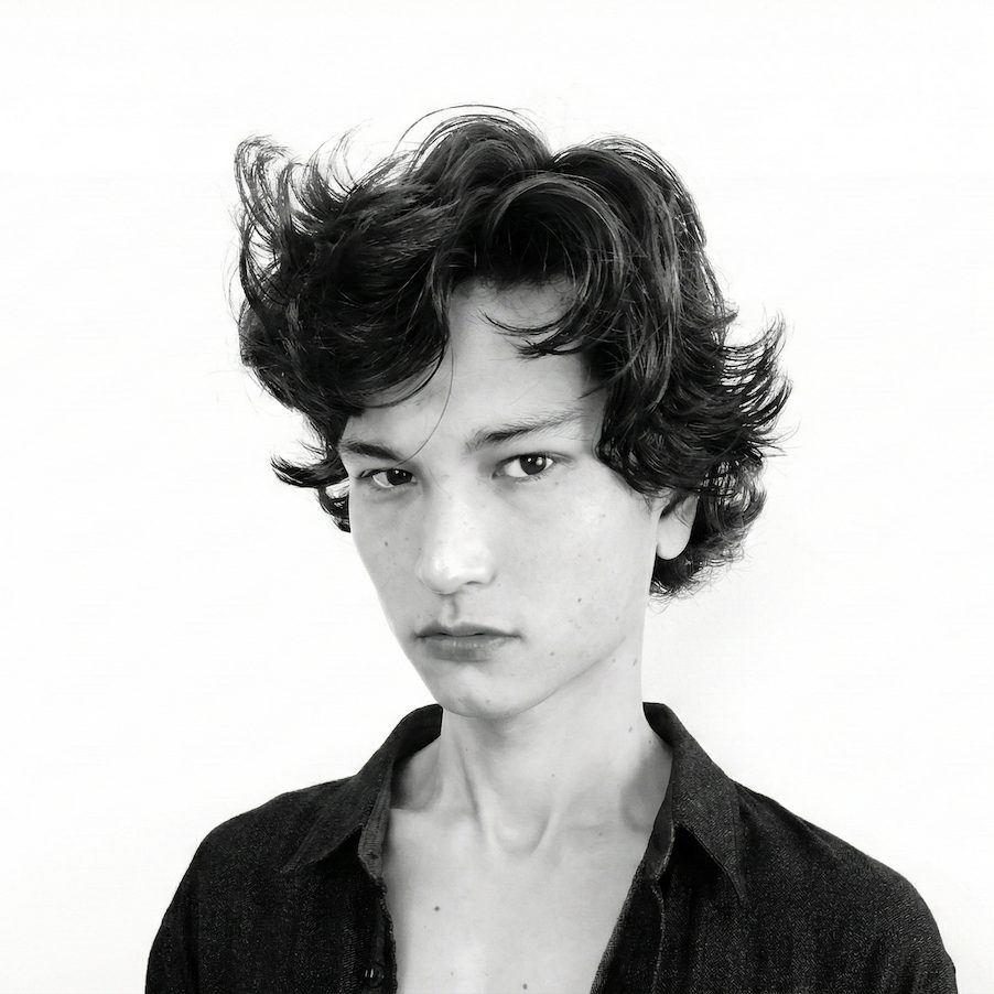 Man with a tousled, side-swept wavy haircut