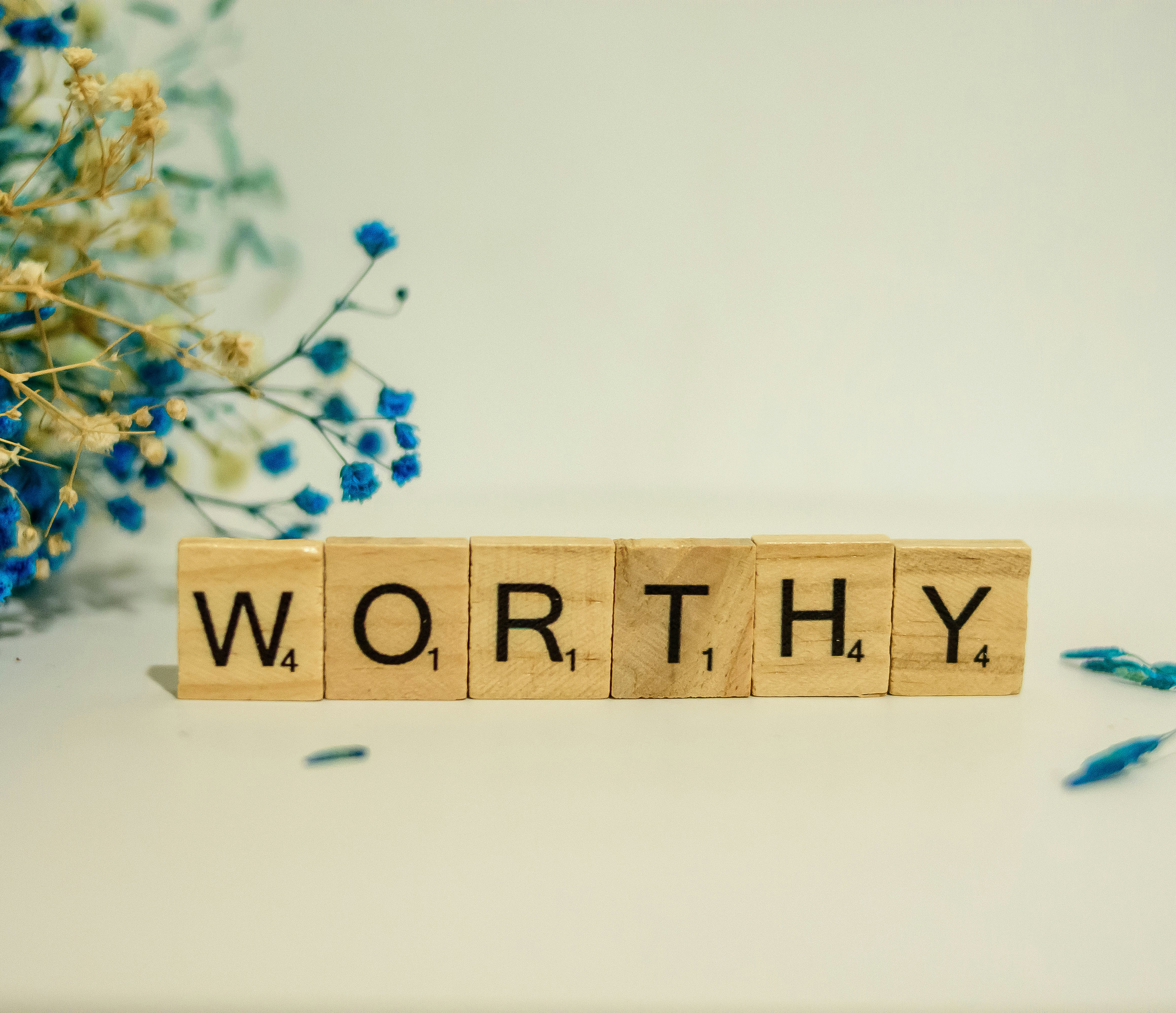 A wooden block spelling the word worthy