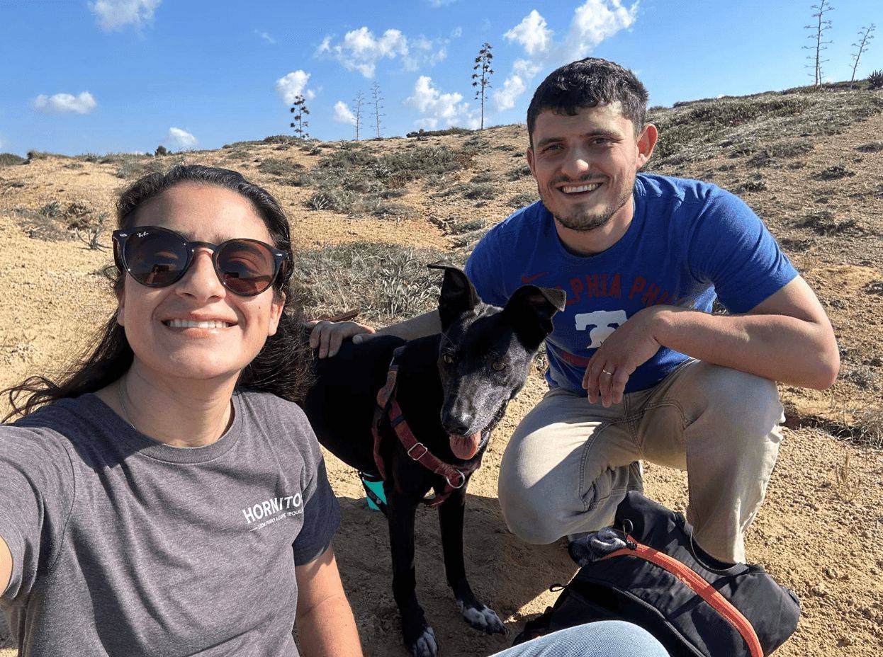 Lanka the rescue dog with her owners outdoors after a hike.