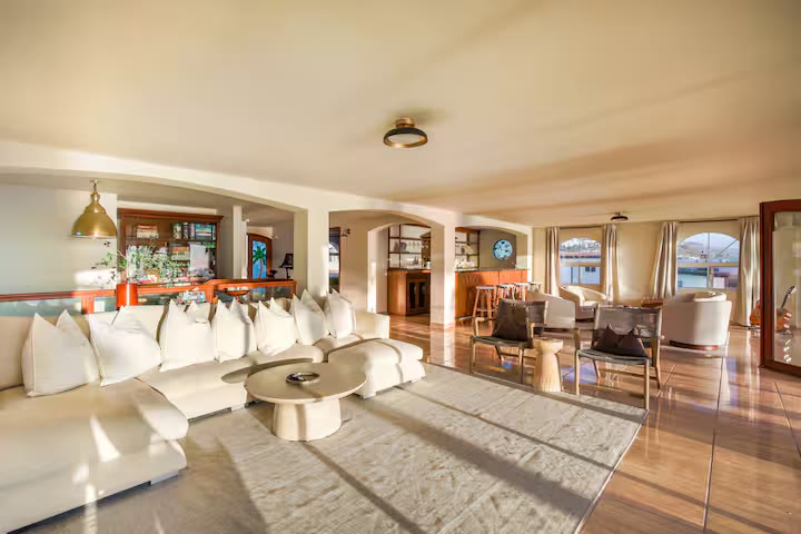 A spacious lounge with a long white sectional, made for gathering in circle