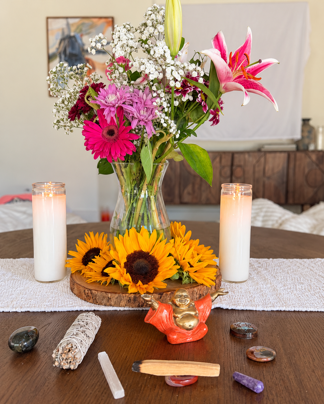 A candlelit altar with sunflowers, lilies and stones from a recent retreat