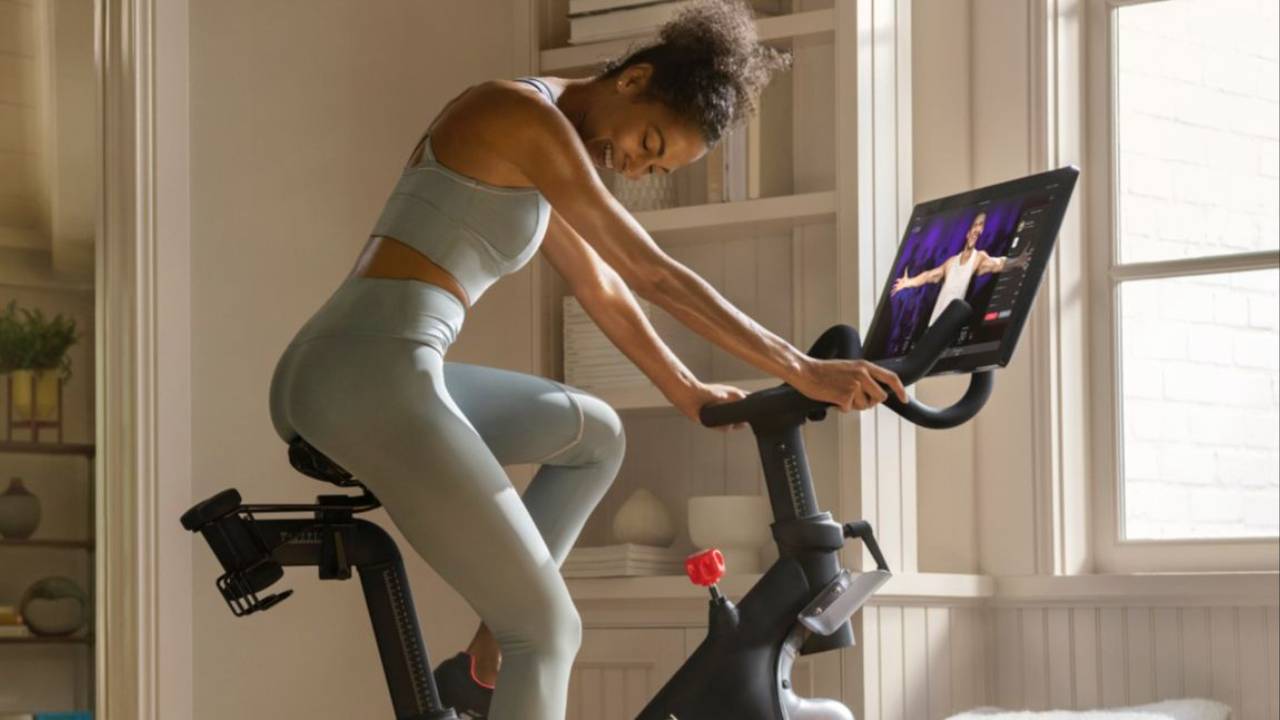 Woman using a Peloton bike