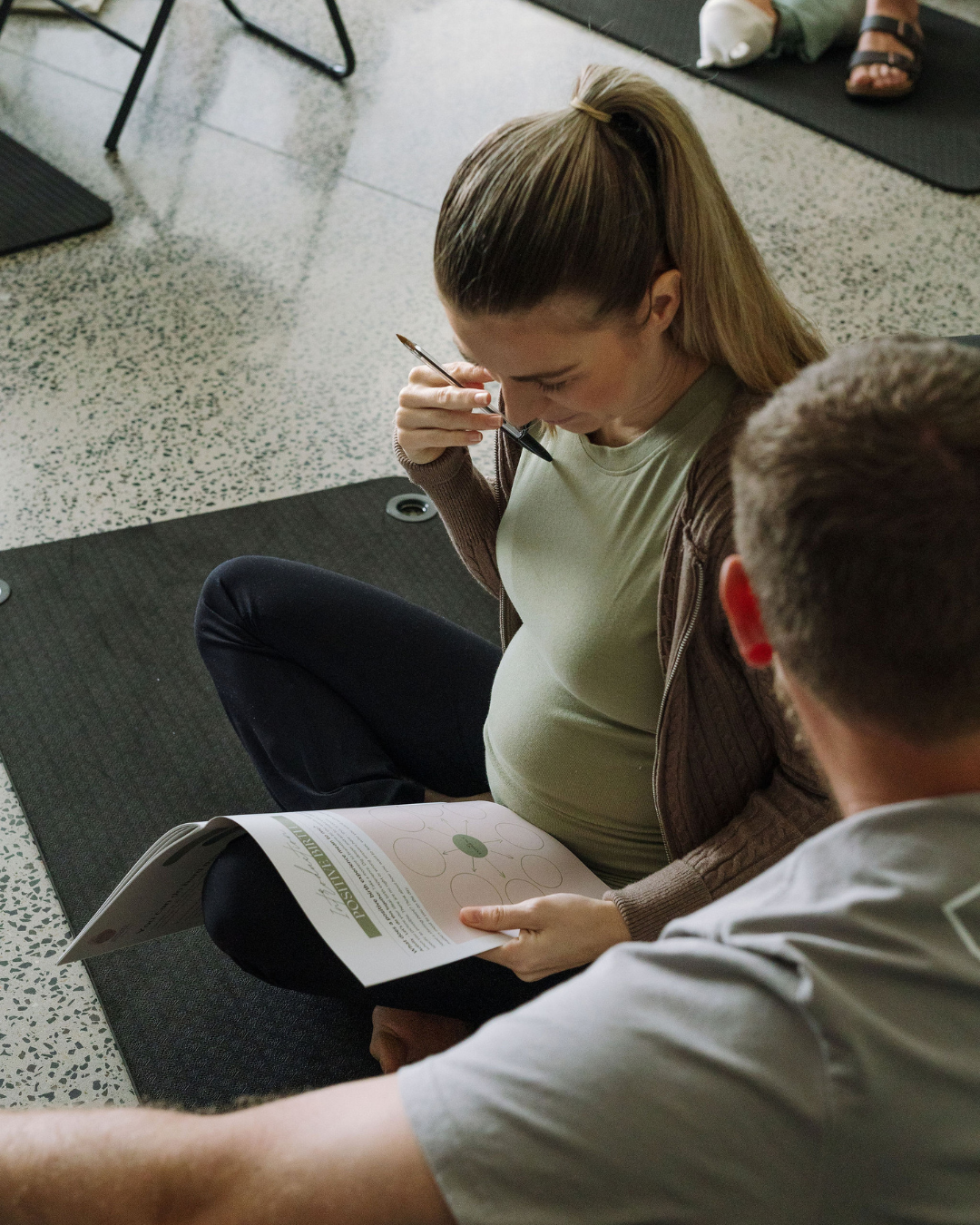 A mum and her partner reading through a birth workbook together