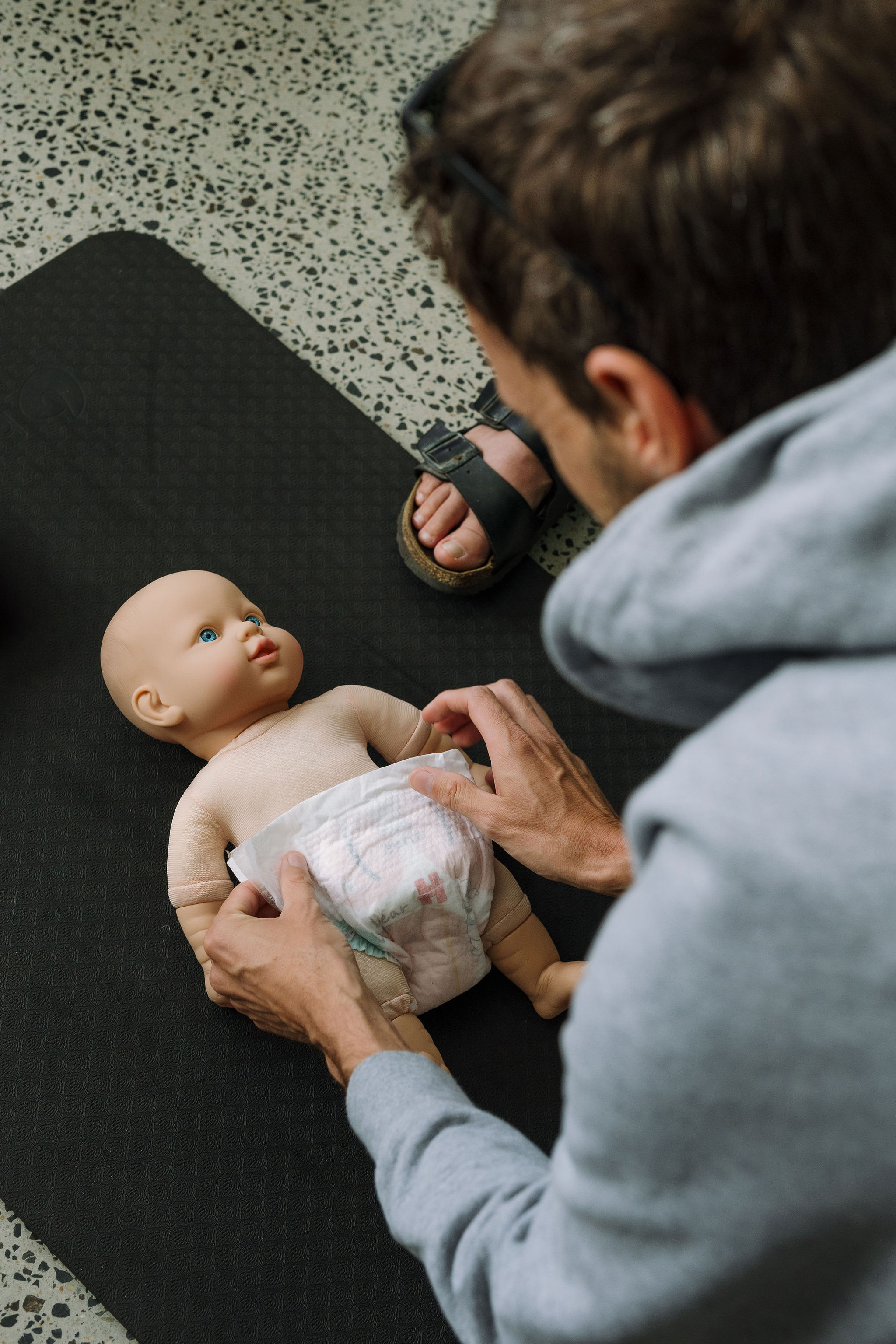 A dad practising newborn care