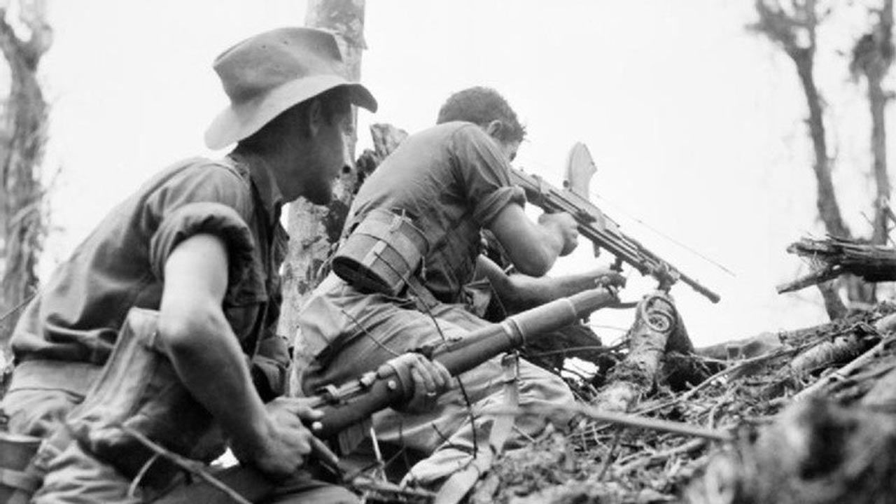 Black and white vintage image of soldiers climbing out of a trench