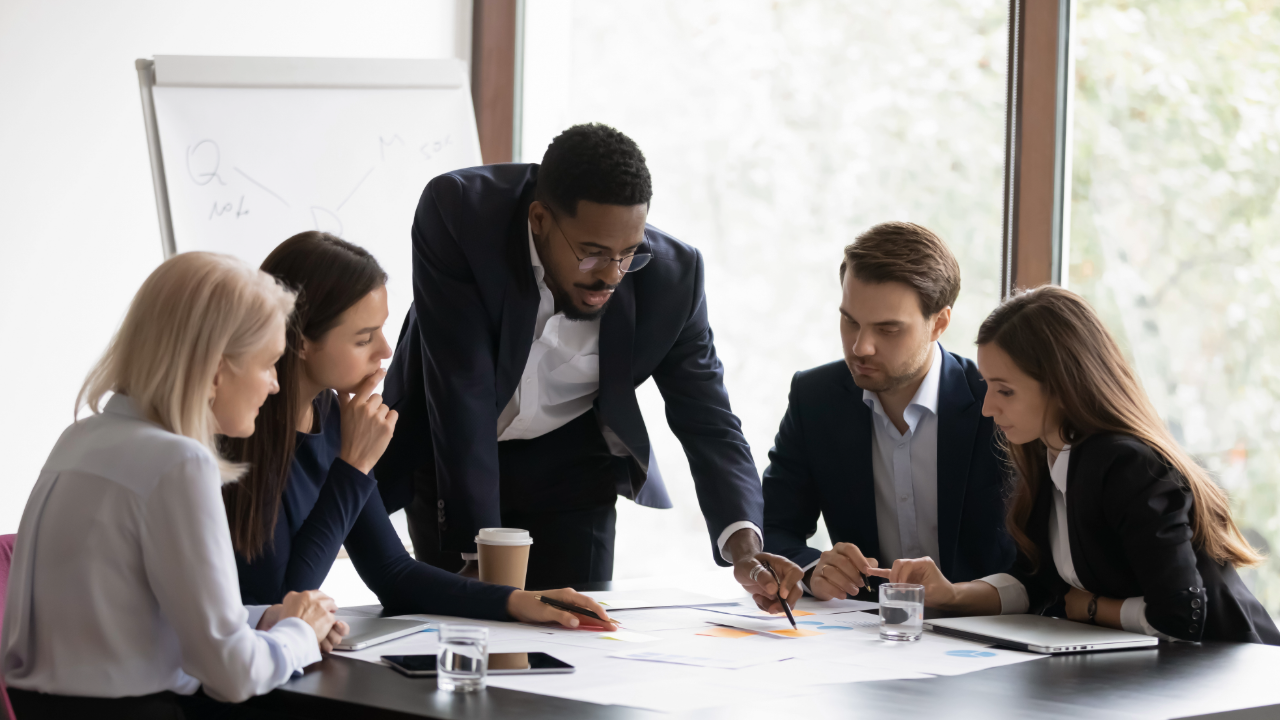 AI Replacing Jobs Is the Wrong Fear. Here's What's Actually Happening to Your Team. Team sitting around table meeting. 