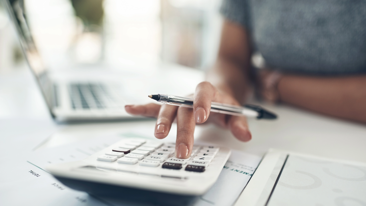 Evaluating the Costs of an AI Rollout, woman doing AI calculations on a calculator