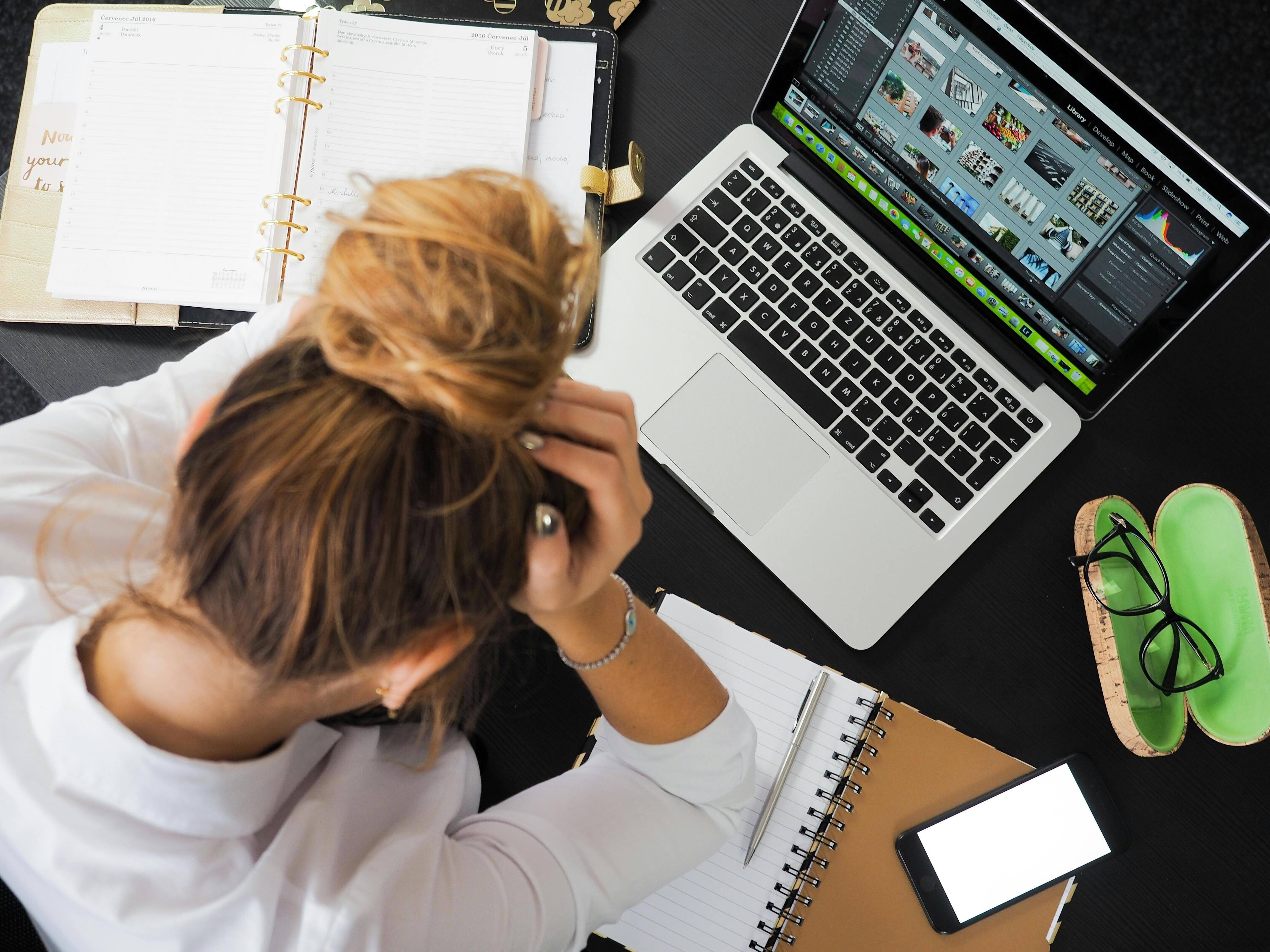 Business professional using a laptop and notebook to plan work
