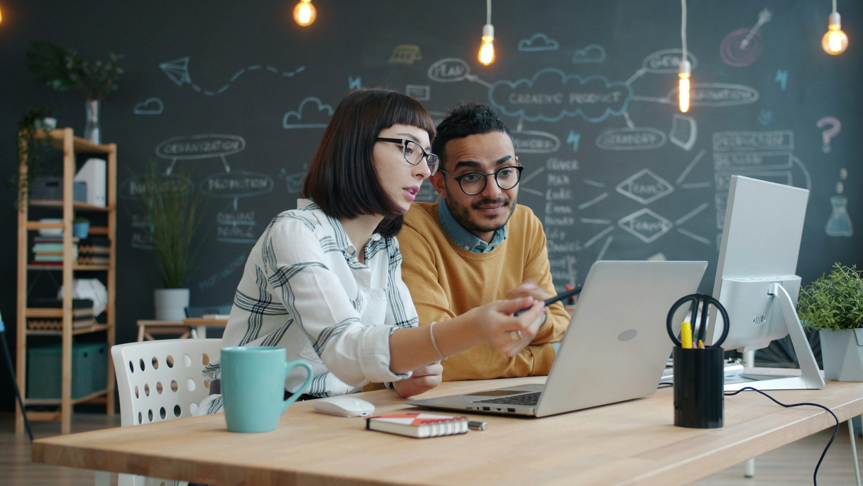 Two business colleagues collaborating around a laptop