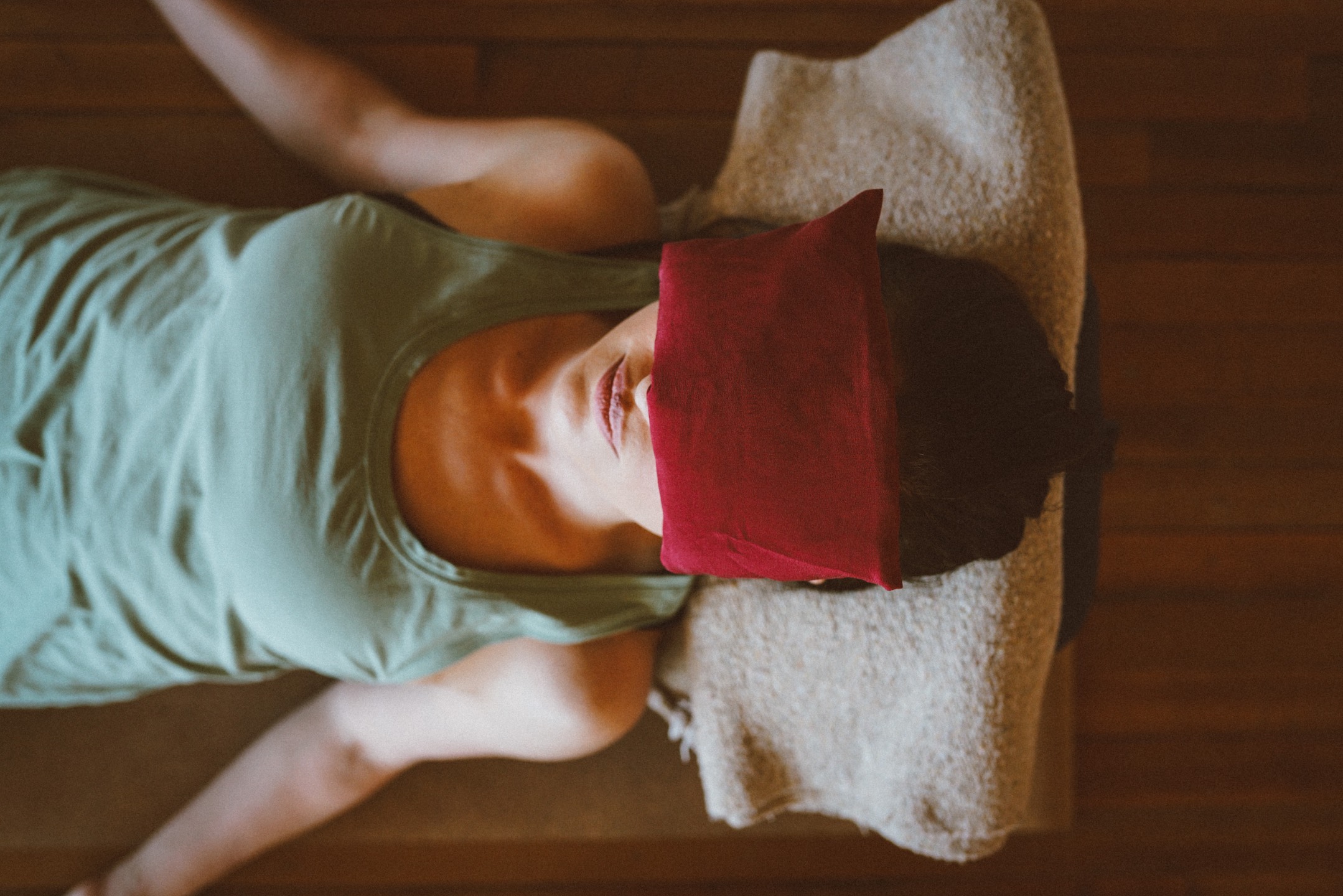 A woman resting with an eye pillow during a reflective practice