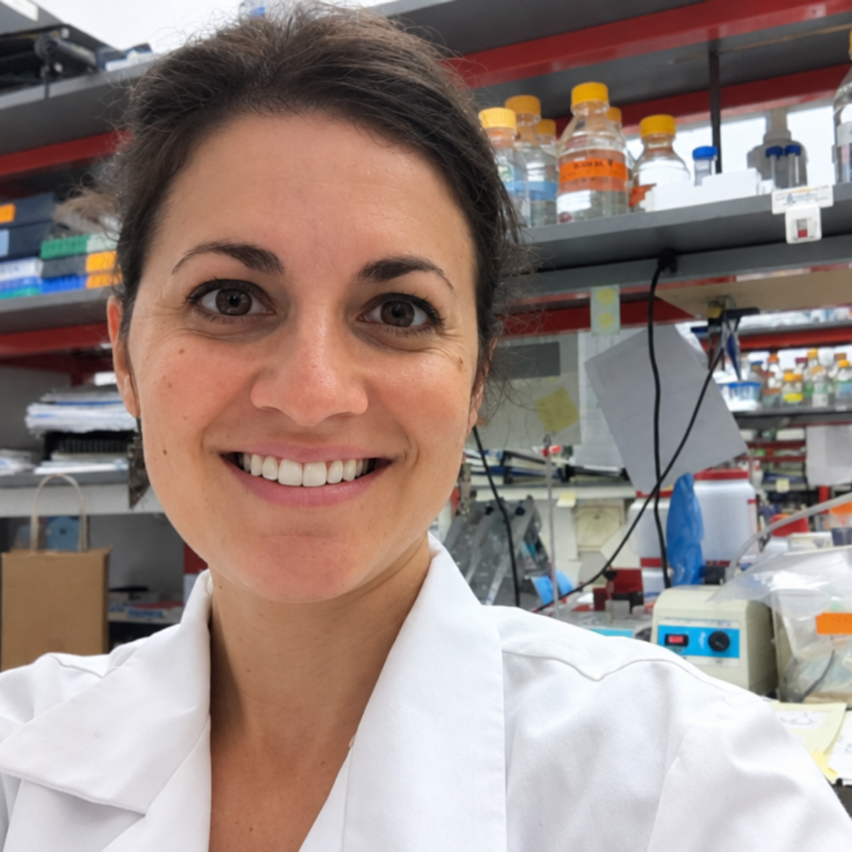 Dr. Jenn Felsted-Knight in a white lab coat in a research lab during her neuroscience career