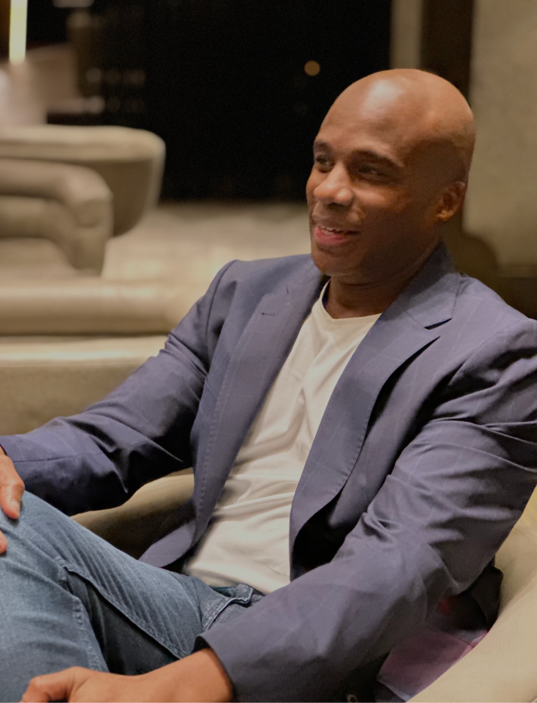Kevin Goins seated in conversation, smiling and listening.