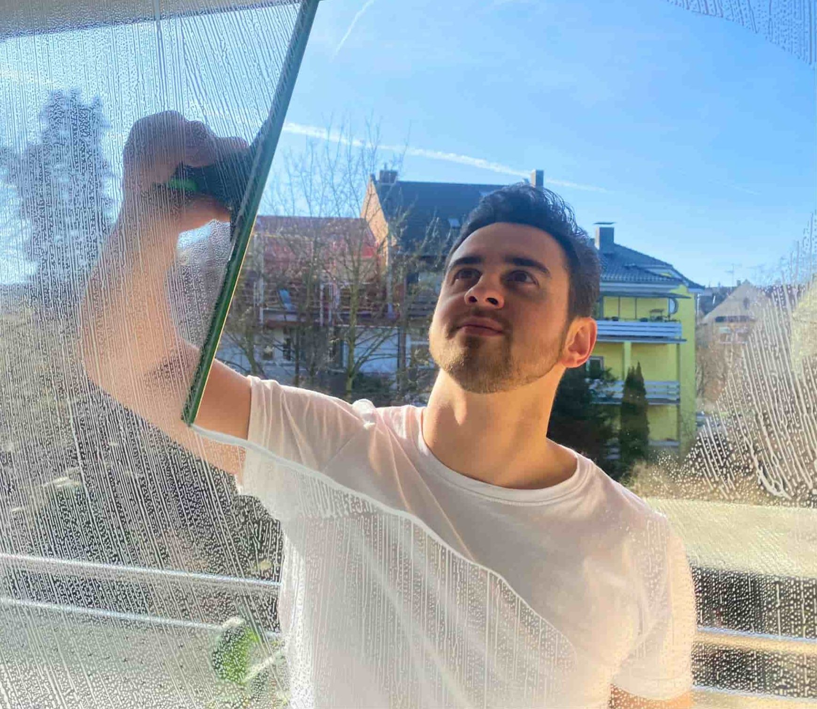 David bei der professionellen Glasreinigung eines Fensters mit UNGER Fensterwischer