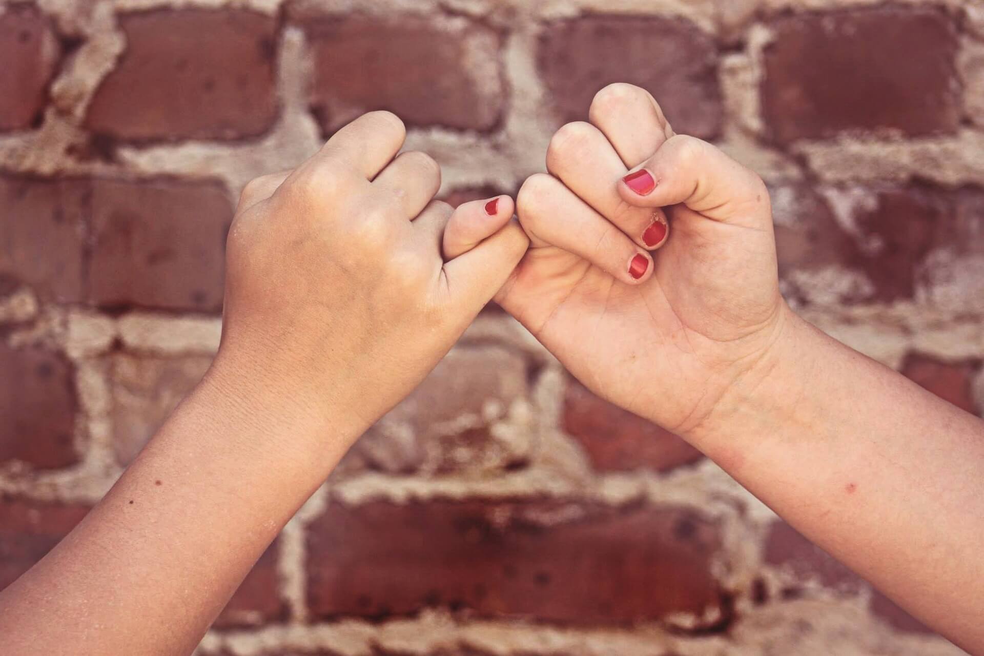 Twee kinderen beloven elkaar iets met hun pink